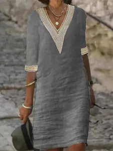 Dettaglio del bordo in pizzo bianco sullo scollo a V di questo abito casual in lino grigio.