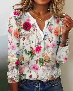 Detailansicht des lebhaften Blumenmusters und V-Ausschnitts auf diesem weißen Langarmshirt