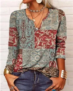 Gros plan du motif patchwork floral bohème vibrant sur un haut à manches longues et col en V femme