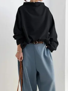 Detail of elegant black loose-fitting long sleeve casual blouse for women with boat neck