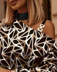 Detalle de eslabones metálicos en blusa de manga larga con estampado geométrico moderno