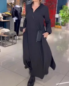 Full-body model view showing the flow and movement of a black maxi dress with side slits