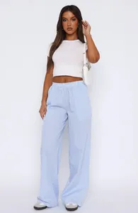 Full body shot showing the stylish fit and flow of the blue striped wide-leg trousers