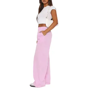 Side view of a model wearing high-waisted pink and white vertical striped wide-leg trousers.