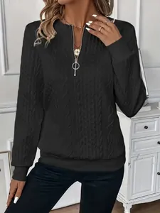 Close-up detail of women's black quarter-zip sweatshirt with cable knit texture