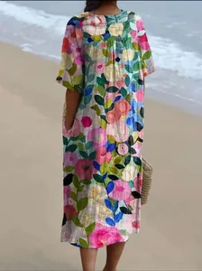 Détail de la vue arrière d'une robe longue ample à imprimé floral coloré sur une plage