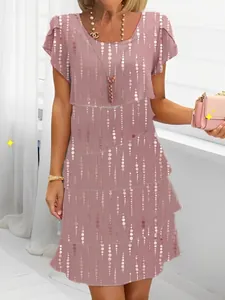 Detail view of a pink tiered chiffon dress with 3D dot print and round neck design.