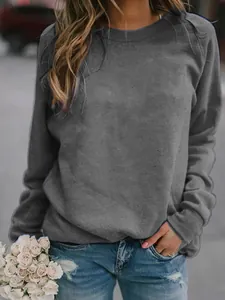 Casual dark gray women's long-sleeve crewneck sweatshirt in outdoor street setting