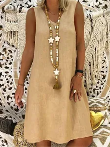 Detail shot of a women's V-neck sleeveless linen dress with star tassel necklace accessory