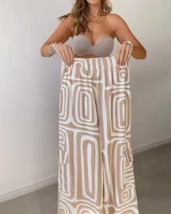 Detailed view of women's high-waisted wide-leg pants with beige geometric digital print