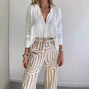 Elegant women's two-piece set featuring white button-up shirt and printed trousers