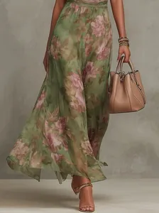 Detail view of green mesh maxi dress with romantic pink floral print and flowing hem.