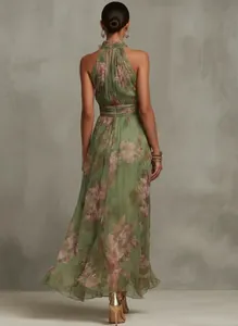 Back view of a green floral halter maxi dress featuring elegant flowing skirt detail