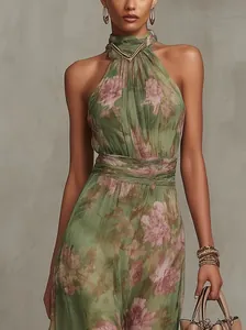 Detailed view of the green floral print and pleated waist of this halter neck maxi dress.