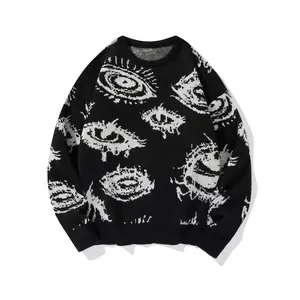 Detailed close-up of white eye jacquard knit pattern on a black oversized sweater.