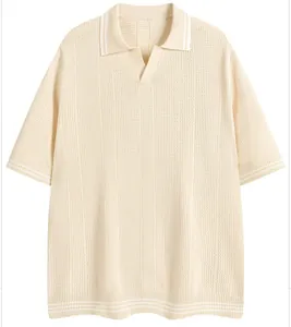Close-up of a cream-colored knitted Polo shirt with striped collar and cuff details.