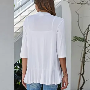 Back view of white knit cardigan showing ruffled hem detail and 3/4 sleeves.