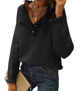 Detail view of black ruffled V-neck sweater with button accents and pleated cuffs