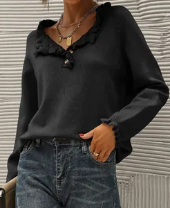 Close-up of black knitted sweater with ruffle collar and button neckline details.