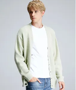 Close-up view of a men's light green knit cardigan with black buttons on a model.