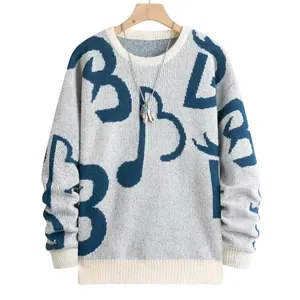 Vista dettagliata di un maglione autunnale in maglia con motivi blu e collo a costine