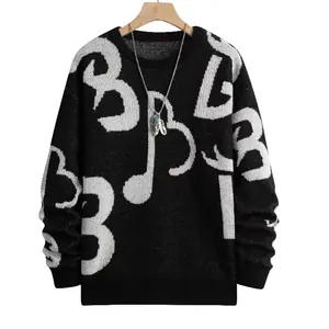 Dettaglio di maglione nero a girocollo con motivi grafici bianchi e note musicali audaci