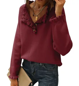 Detail view of burgundy knit sweater featuring ruffled collar and decorative buttons