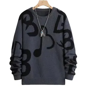 Primo piano di un maglione grigio da uomo con motivi a lettere astratte nere e collana