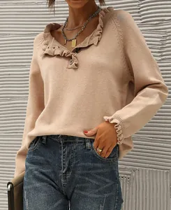 Detailed view of women's beige knit sweater with ruffled collar and buttoned neckline