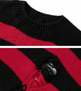 Detailaufnahme eines schwarz-rot gestreiften Strickpullovers mit modischen Löchern.