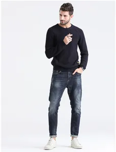 Detail view of a men's navy blue slim fit crew neck ribbed knit sweater on model