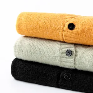 Stacked soft knitted V-neck cardigans in mustard yellow, mint green, and black