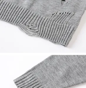 Primo piano di dettagli strappati e polsini a coste su un maglione grigio in maglia
