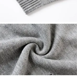Dettaglio del tessuto di un maglione a maglia grigio con trama morbida e strappi