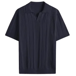 Detail view of a men's navy blue textured knit short sleeve polo shirt with v-neck.