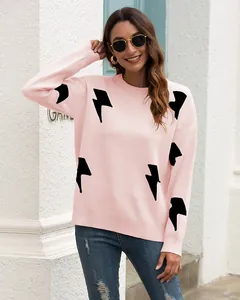 Detail of pink long-sleeved knit sweater featuring bold black lightning bolt patterns.