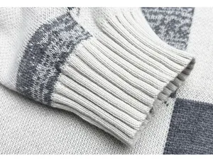 Close-up of ribbed cuff detail on a men's knitted sweater with geometric patterns.