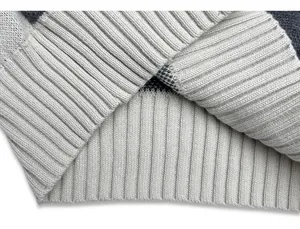 Close-up of ribbed hem detail on grey striped knitted sweater