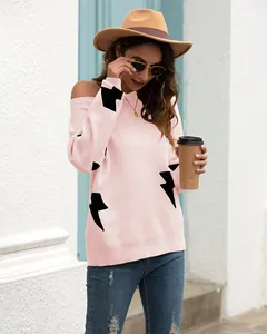 Detail of pink off-shoulder knitted sweater featuring bold black lightning bolt patterns