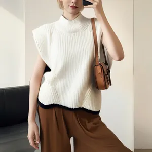 Detail view of a white knitted sleeveless turtleneck sweater vest with rib texture