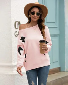 Detailed view of women's pink off-shoulder knitted sweater featuring black jacquard patterns