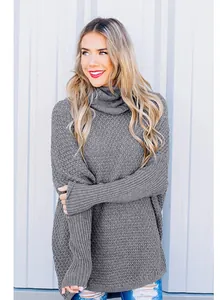 Detail of a loose grey turtleneck sweater with ribbed knit sleeves on a model.