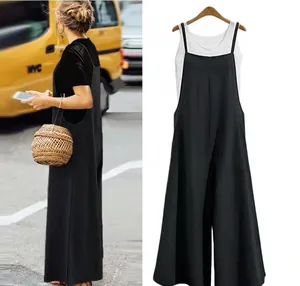 Detail view of a loose black wide-leg jumpsuit presented on a wooden clothes hanger.
