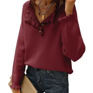 Women's burgundy ruffle V-neck knitted sweater with button detail and long sleeves.