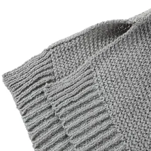 Dettaglio ravvicinato della trama di un maglione grigio in maglia con bordo