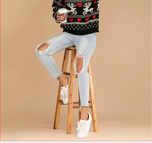 Vue détaillée du pull tricoté de Noël avec rennes et jean bleu délavé