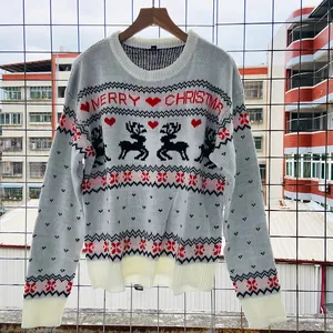 Vue détaillée d'un pull de Noël blanc en tricot avec des motifs de rennes et de cœurs