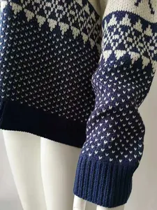 Detail of Christmas sweater featuring navy blue and white geometric jacquard knit pattern