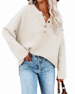 Detailed texture of off-white loose knit sweater with three buttons at the neckline