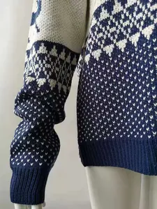 Detailed view of the geometric reindeer jacquard and ribbed cuffs on this knitted sweater